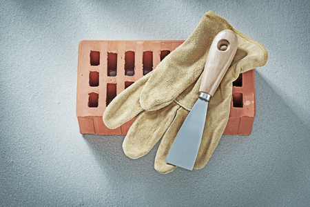 Red bricks safety gloves plastering trowel on concrete background bricklaying concept.の写真素材