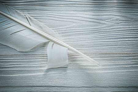 Vintage feather on wooden board top view.の写真素材