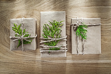 Handmade present boxes wrapped in shop paper with green branch holidays concept.の写真素材