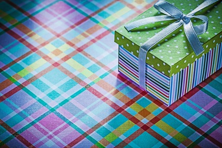 Present in cardboard box on checked table cloth holidays concept.の写真素材
