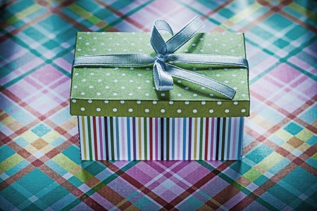 Present in cardboard box on checked fabric holidays concept.