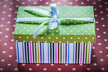 Decorated gift box on red background holidays concept.