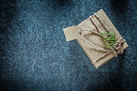 Wrapped gift box with thuya branch on black background holidays concept.の写真素材