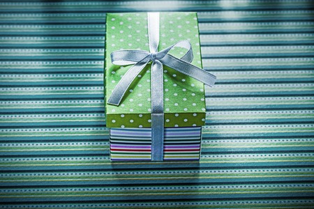 Present box on striped background holidays concept.