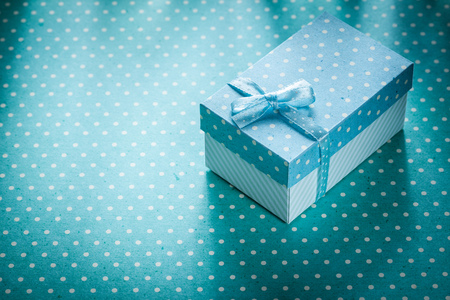 Present box on blue polka-dot background holidays concept.の写真素材
