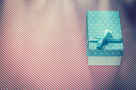 Wrapped present box on red striped textile celebrations concept.の写真素材