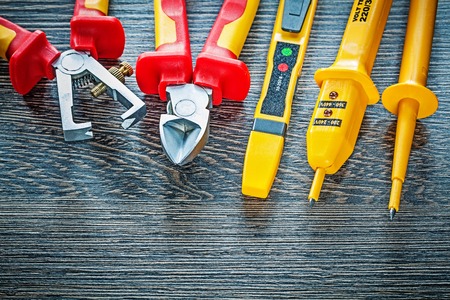 Electrical tester nippers insulation strippers on wooden board.