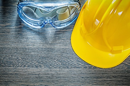 Protective goggles hard hat on wooden board.の写真素材