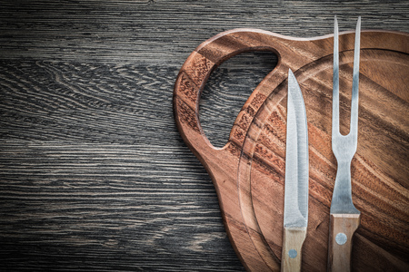 Meat fork knife chopping board on vintage wooden background.の写真素材
