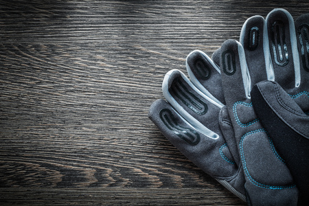 Pair of protective gloves on wooden board.