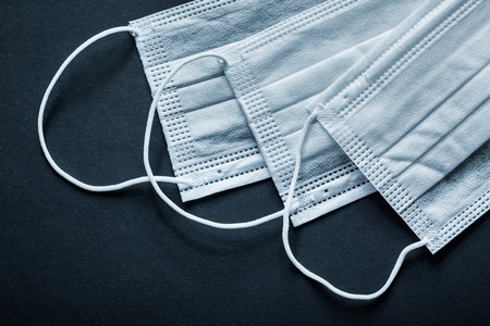 Disposable sterile face masks on black background.