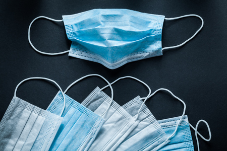 Disposable respiratory medical masks on black background.