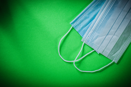 Disposable sterile surgical mask on green background.の写真素材