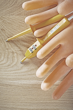 Electric tester pair of electricians gloves on wooden board.の写真素材