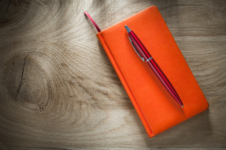 Orange notebook pen top view.の写真素材