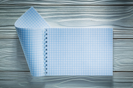 Checked notebook on white wooden board.の写真素材