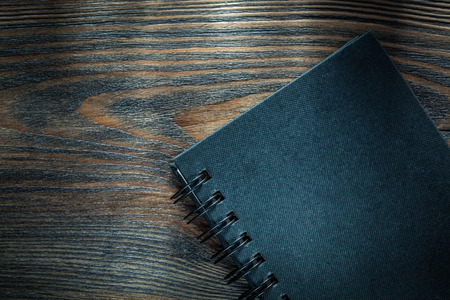 Black notepad on vintage wooden board.の写真素材