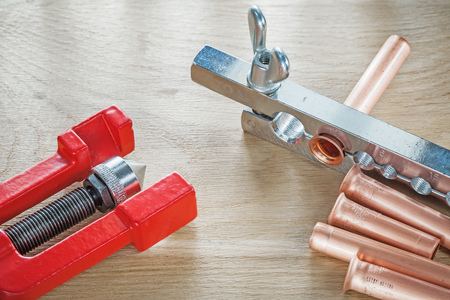 Brass flared pipes flaring clamp brake plumber on wooden board.の写真素材