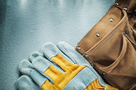 Leather tool belt protective gloves on concrete background.の写真素材