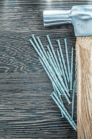 Stainless construction nails claw hammer on wooden board.の写真素材
