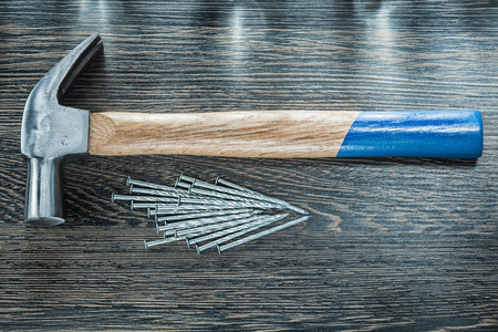 Stack of construction nails claw hammer on wooden board.の写真素材