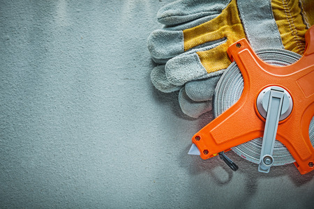 Safety gloves tape measure on concrete background.の写真素材