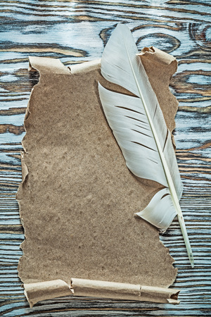Vintage parchment feather on wooden board.の写真素材