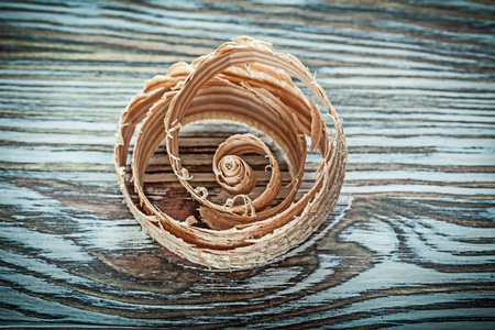 Curled planning shavings on wooden board.の写真素材