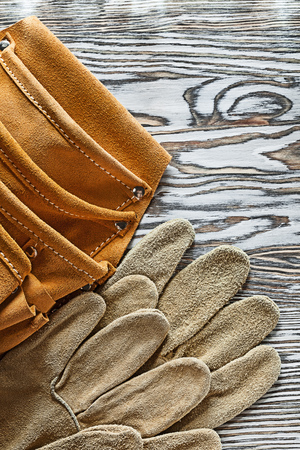 Leather safety gloves tool belt on wooden board.の写真素材