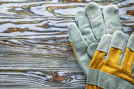 Yellow protective gloves on wooden board.