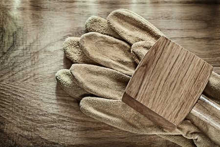 Pair of leather protective gloves wooden mallet on wood board.の写真素材