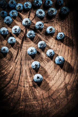 Heap of bilberries on vintage shabby board.の写真素材