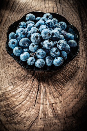 Blueberries on plate vintage grunge board.の写真素材