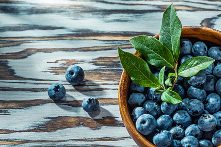 Juicy huckleberries in wooden bowl.の写真素材
