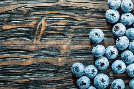 Heap of blueberries on vintage wooden board.の写真素材