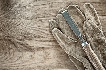 Firmer chisel safety gloves on wooden board.の写真素材