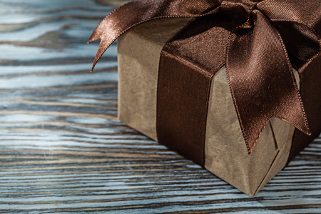 Brown gift box with tied bow on wooden background.の写真素材