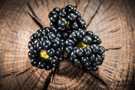 Ripe blackberry on vintage wooden board.