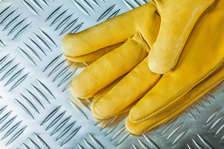 Pair of leather safety gloves on corrugated metal texture.の写真素材