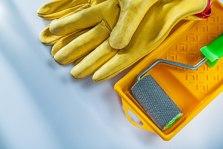 Leather safety gloves paint tray roller on white background.