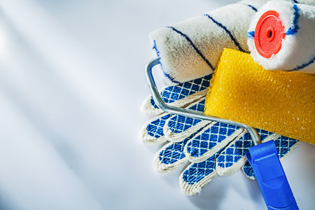 Safety gloves paint rollers on white surface.の写真素材