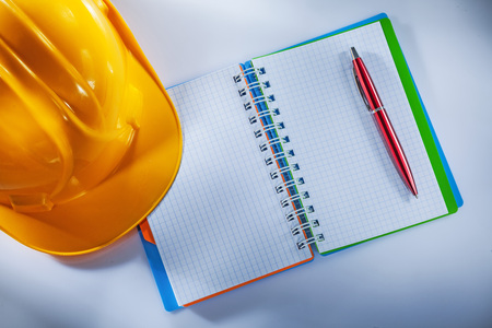 Hard hat notepad pen on white background.の写真素材