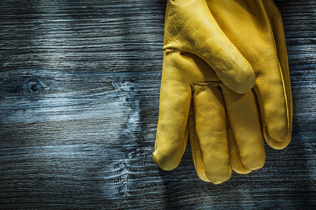Pair of safety gloves on wooden board.
