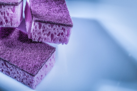 Violet dishwashing sponges on white surface.の写真素材