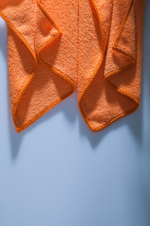 Orange kitchen washcloth on white background.の写真素材