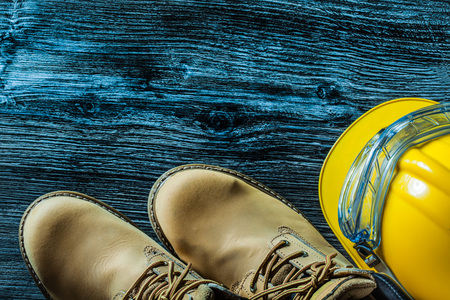 Safety boots hard hat goggles on wooden board.の写真素材