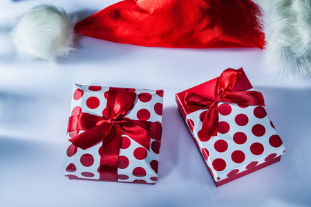 Red Santa hat wrapped present box on white surface.