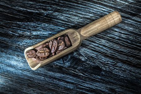 Coffee seeds in scoop on wooden board.の写真素材