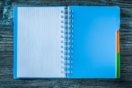 Opened notepad on wooden board.