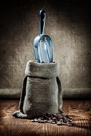 burlap sack and metalic scoop with coffee beansの写真素材